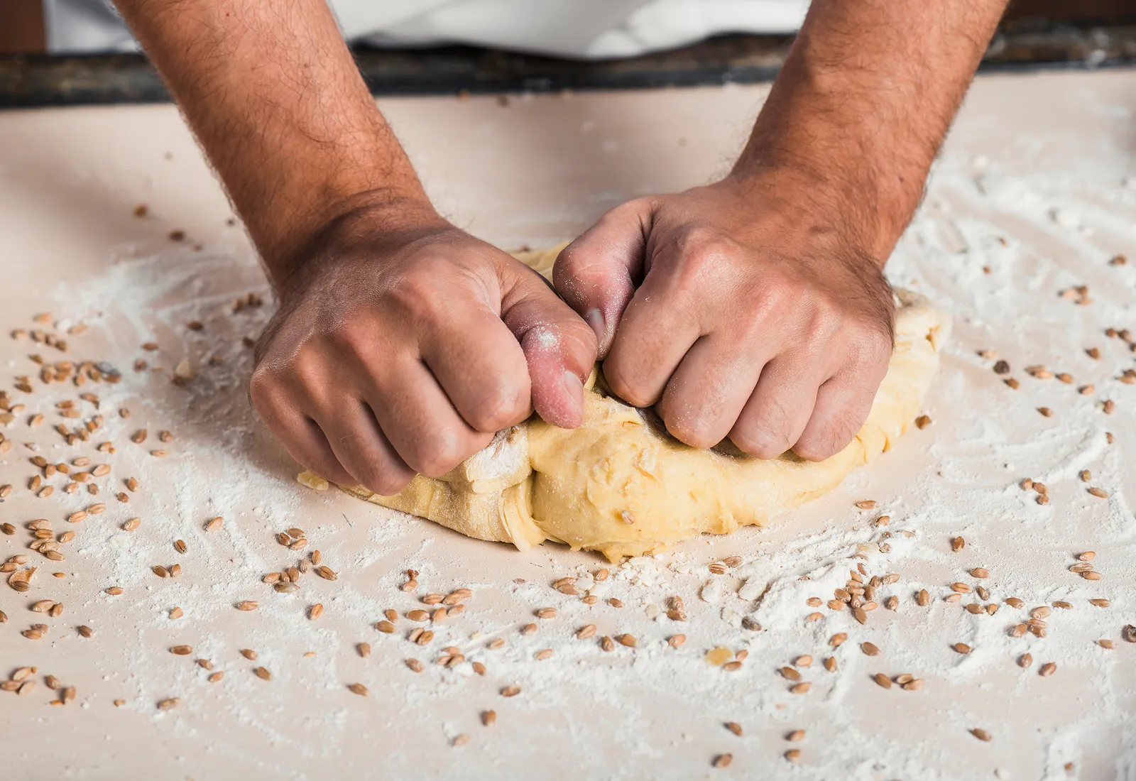 close up baker s hand kneading dough 1 converted